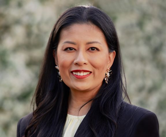 woman in black suits smiles for head shot